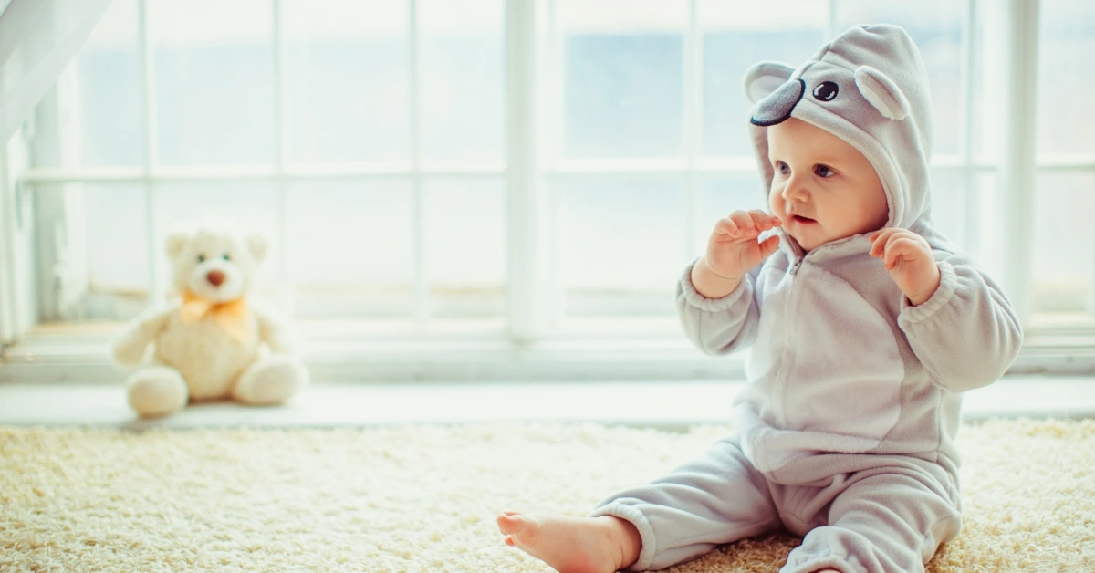 baby wearing the organic baby clothes in india with toys
